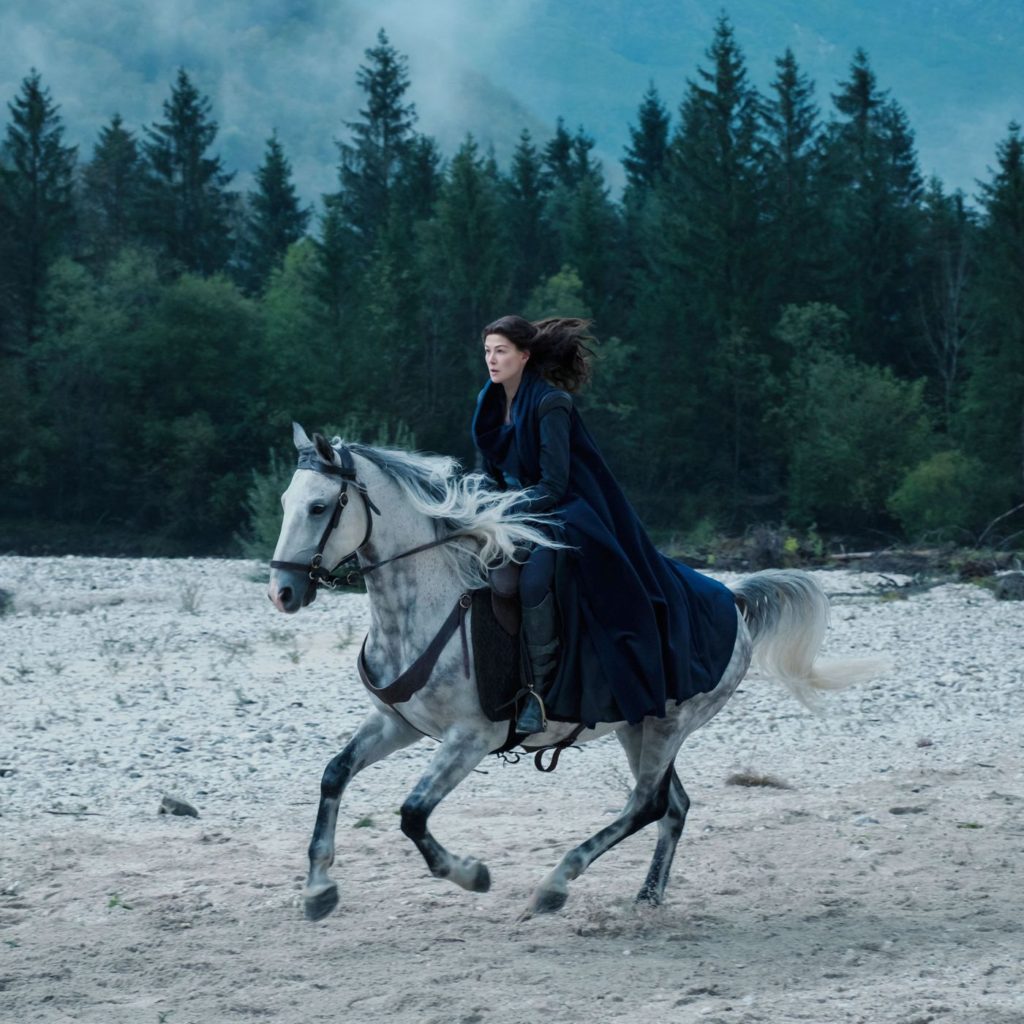 Person riding horse. Set: Riding horse through the valley on a cloudy and dark setting